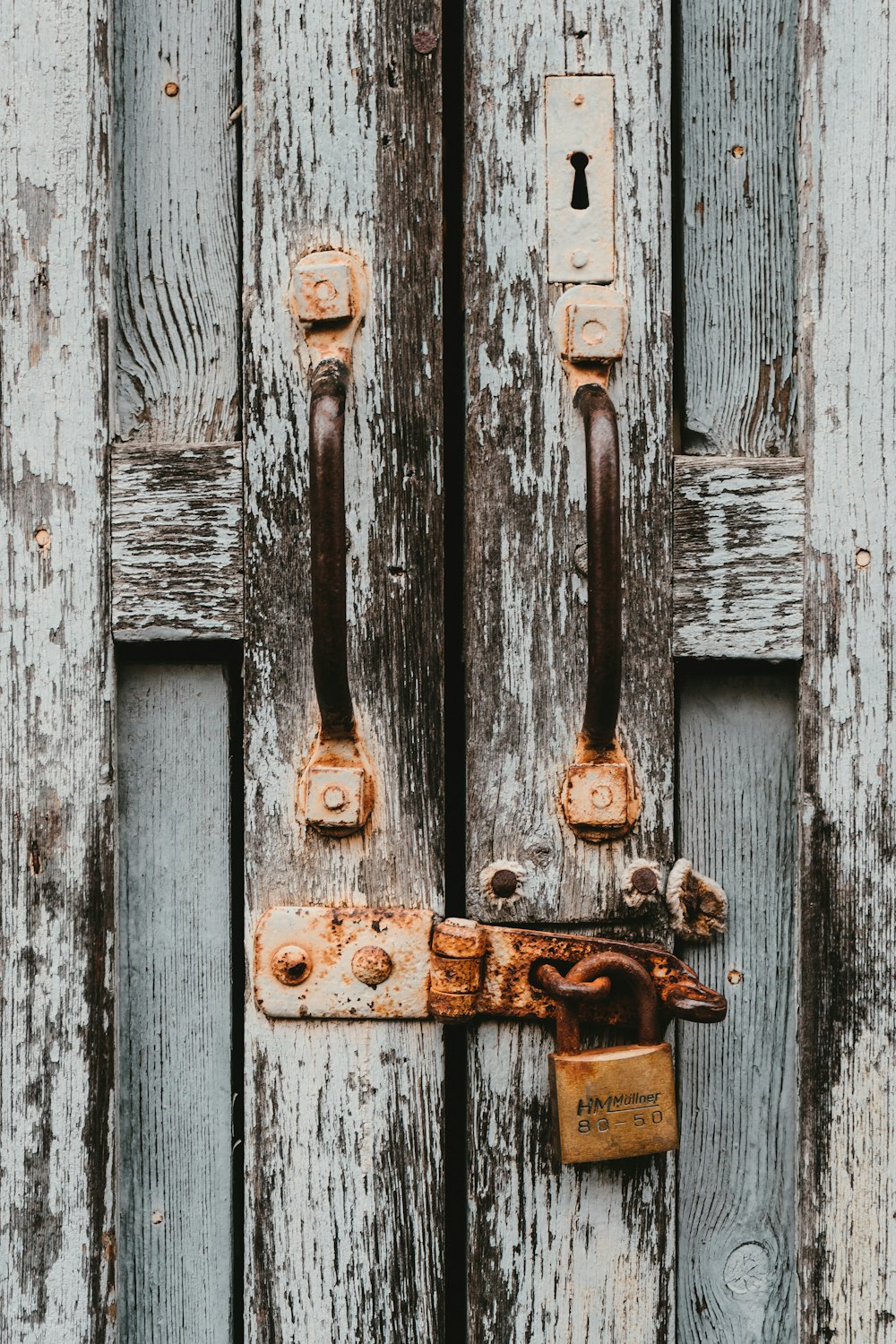 white and brown wooden door with padlock