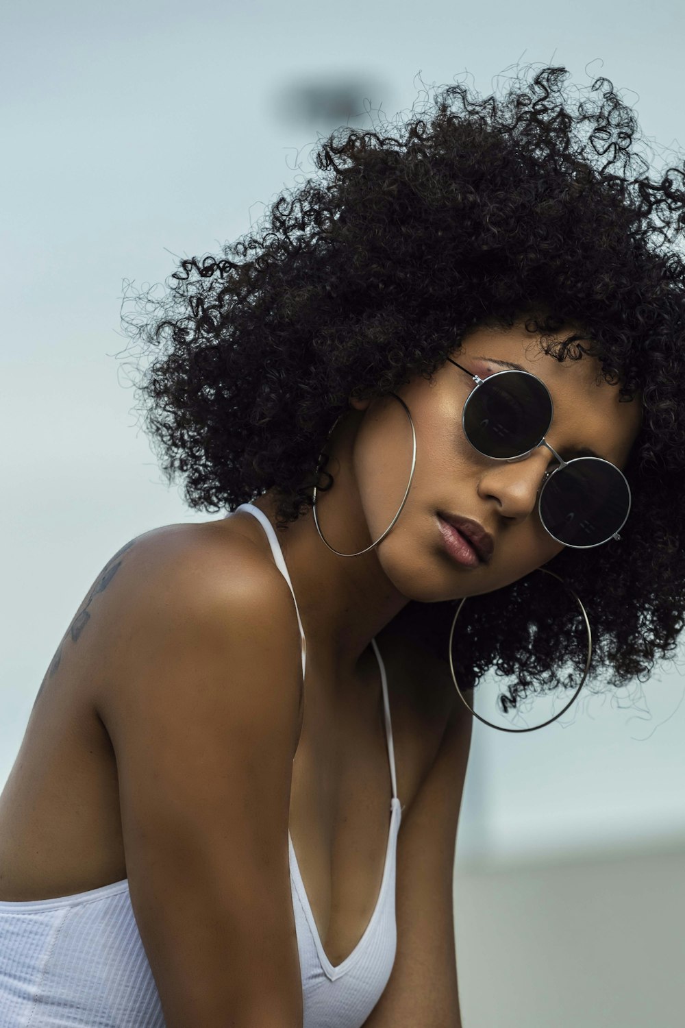 woman in white tank top wearing black sunglasses