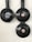Three black circular electrical fixtures mounted on a light wall. The top-left fixture is a plug socket labeled 'Berker', while the other two have central buttons or lights.