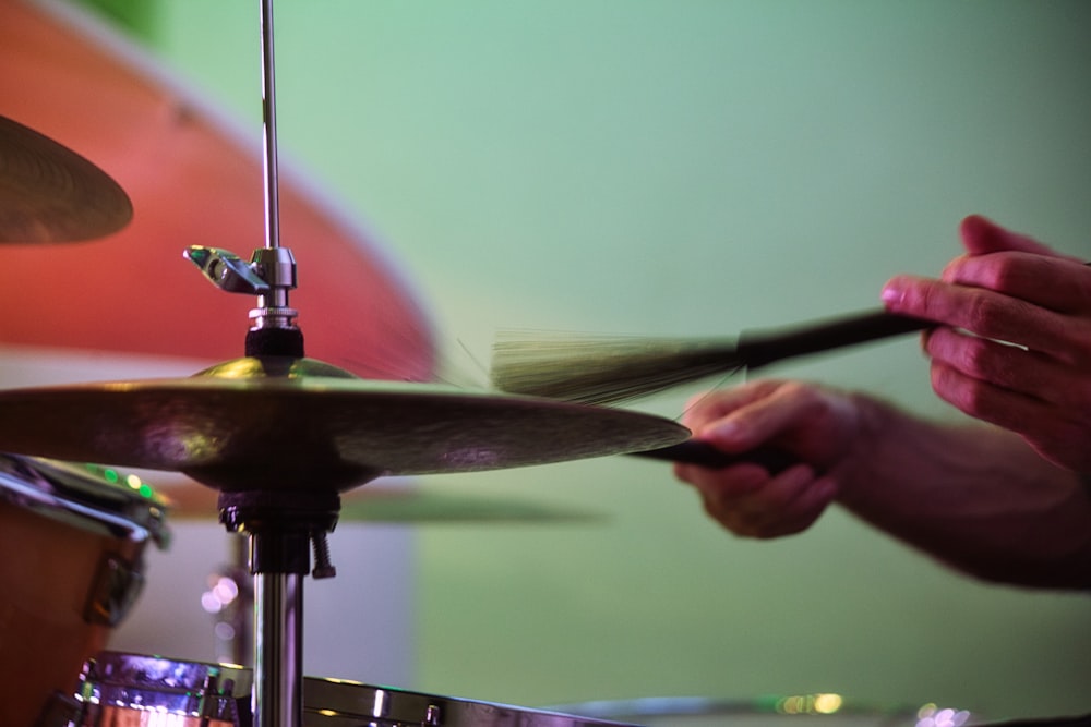 person playing drum stick in close up photography