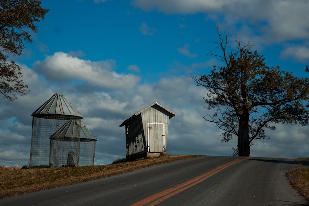 gray wooden house beside bare trees under blue sky during daytime