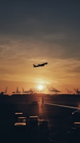 silhouette of airplane flying over the people during sunset