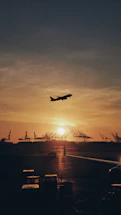 silhouette of airplane flying over the people during sunset