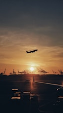 silhouette of airplane flying over the people during sunset