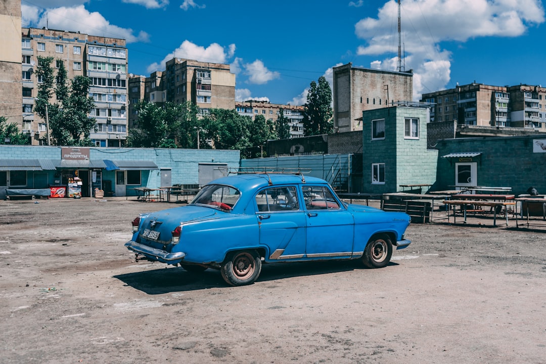 blue vintage car parked on side of the road during daytime