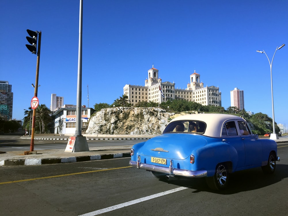 Blaues Coupé tagsüber unterwegs