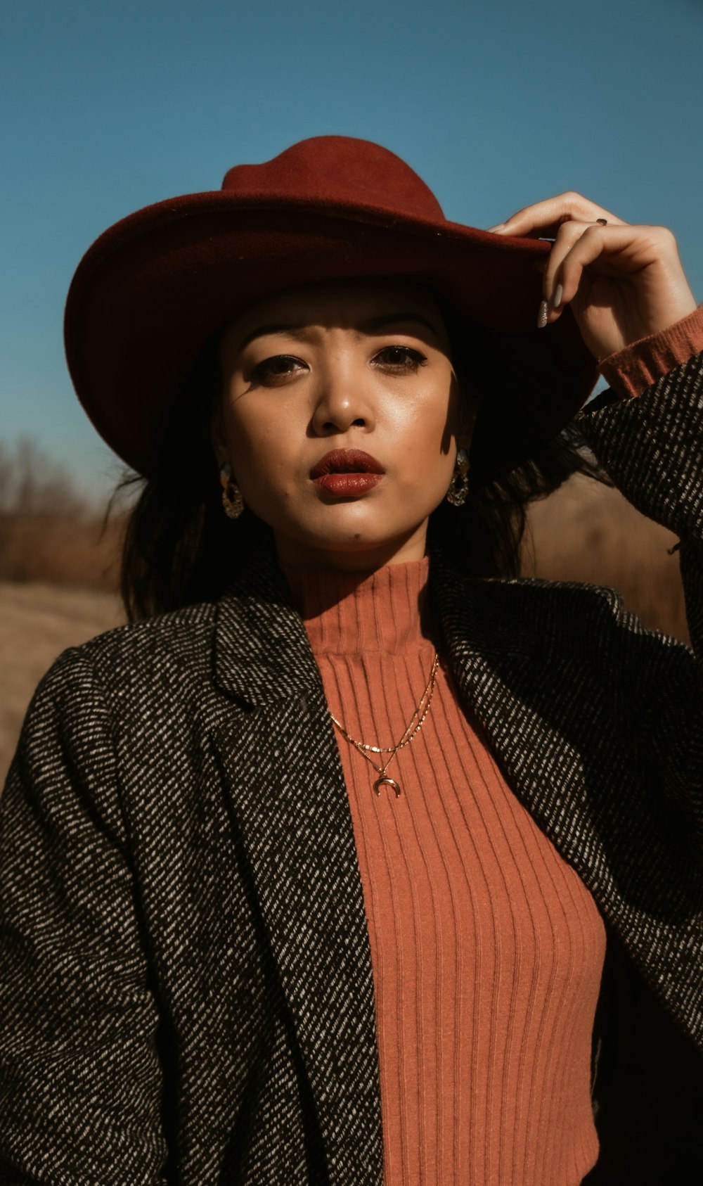 woman in black and white pinstripe blazer and orange shirt