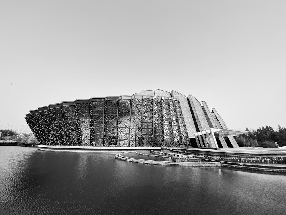 grayscale photo of building near body of water