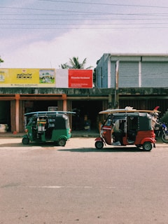 red and black auto rickshaw parked beside white building