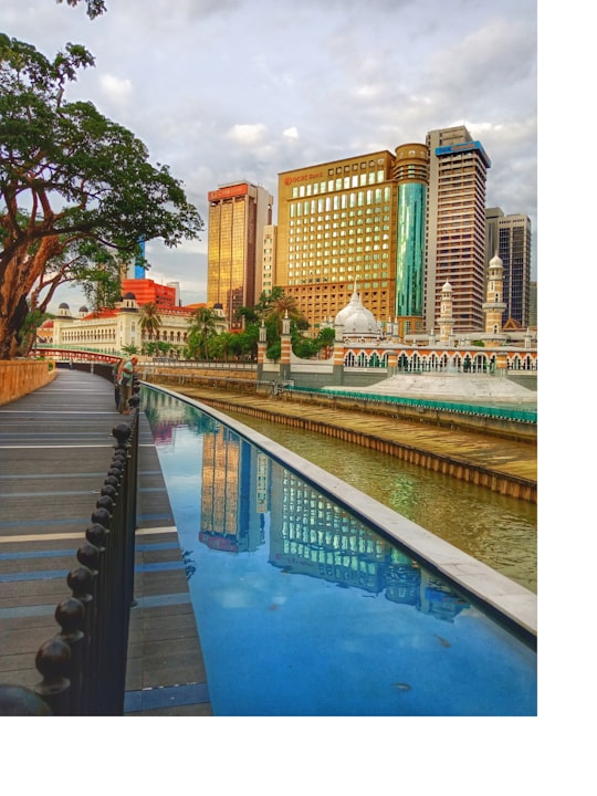 brown concrete building near swimming pool during daytime in Jamek Mosque of Kuala Lumpur Malaysia