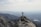 Man reaching the summit with a panoramic mountain view behind him