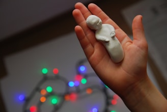white heart ornament on persons hand