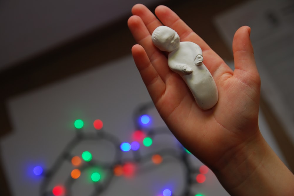 white heart ornament on persons hand