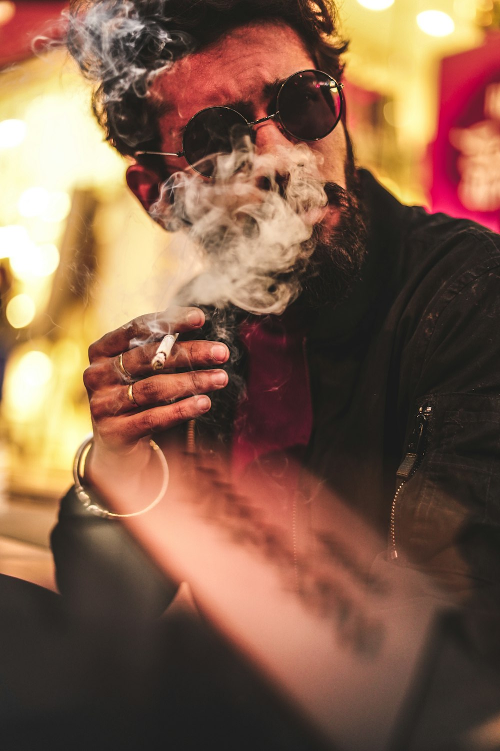 man in black leather jacket smoking