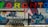 Graffiti art on a brick wall featuring the word 'Toronto' in large, colorful letters. Below, various cartoon-style characters are depicted, including a large cat with prominent eyes, a squirrel with hockey gear, and other playful figures. Gas meters and pipes are present at the bottom of the mural.