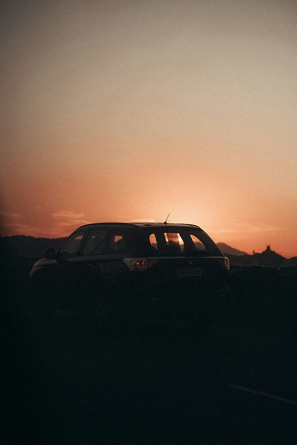 black suv on gray sand during sunset