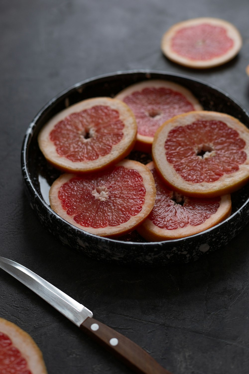 검은 세라믹 그릇에 얇게 썬 토마토