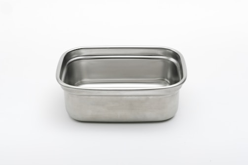 A rectangular stainless steel container with rounded corners against a plain white background. The metal surface is smooth and shiny, reflecting light subtly.