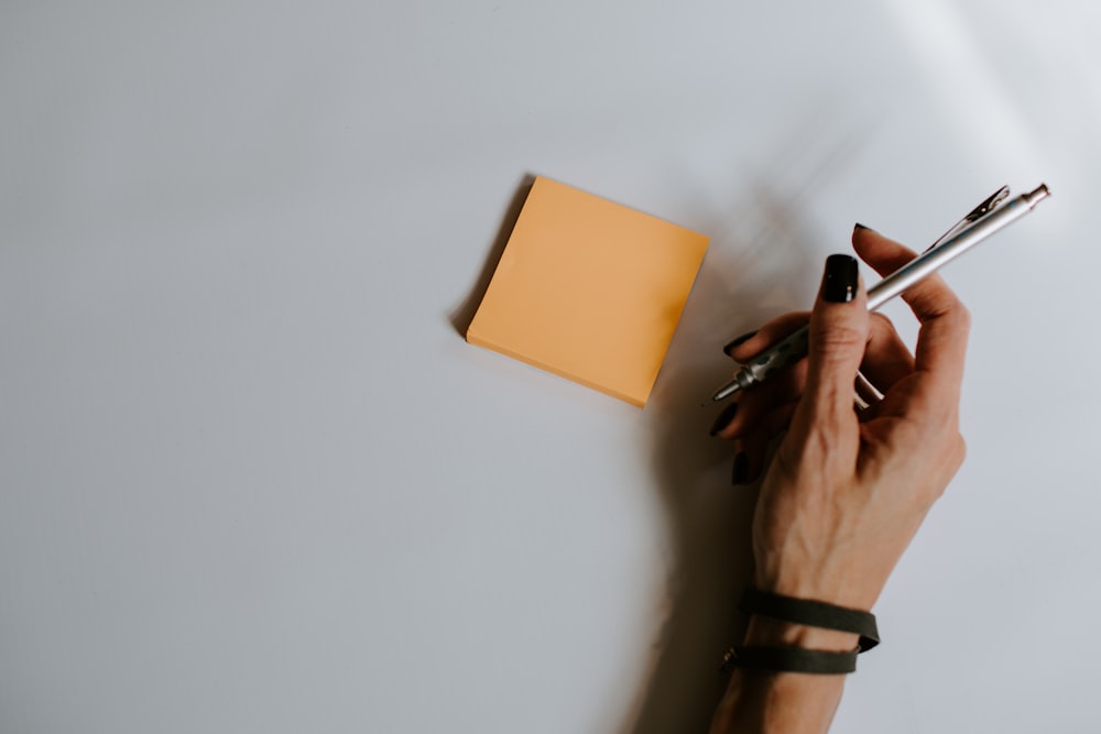 person holding yellow sticky notes