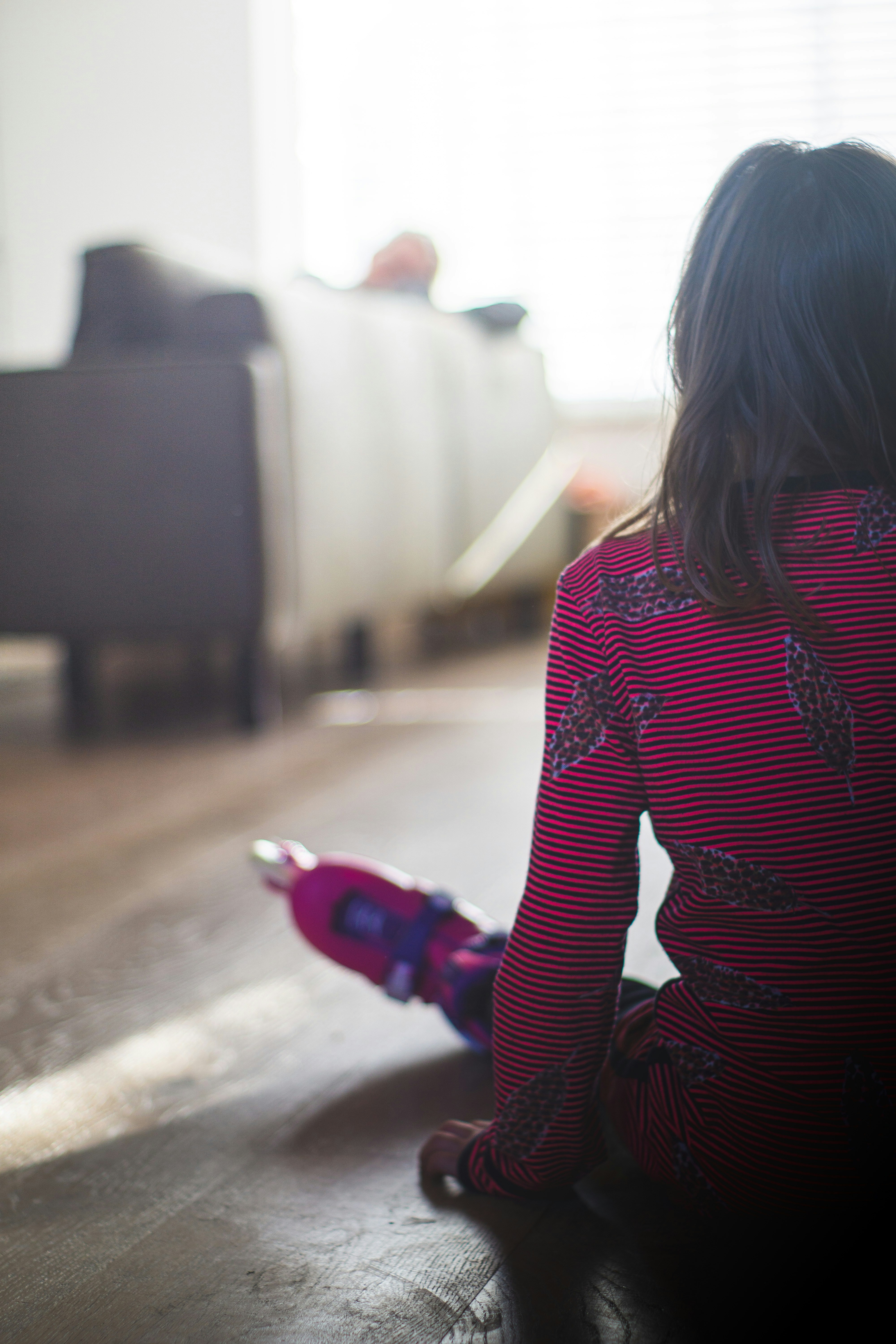 woman in red and black striped long sleeve shirt walking on street during daytime
