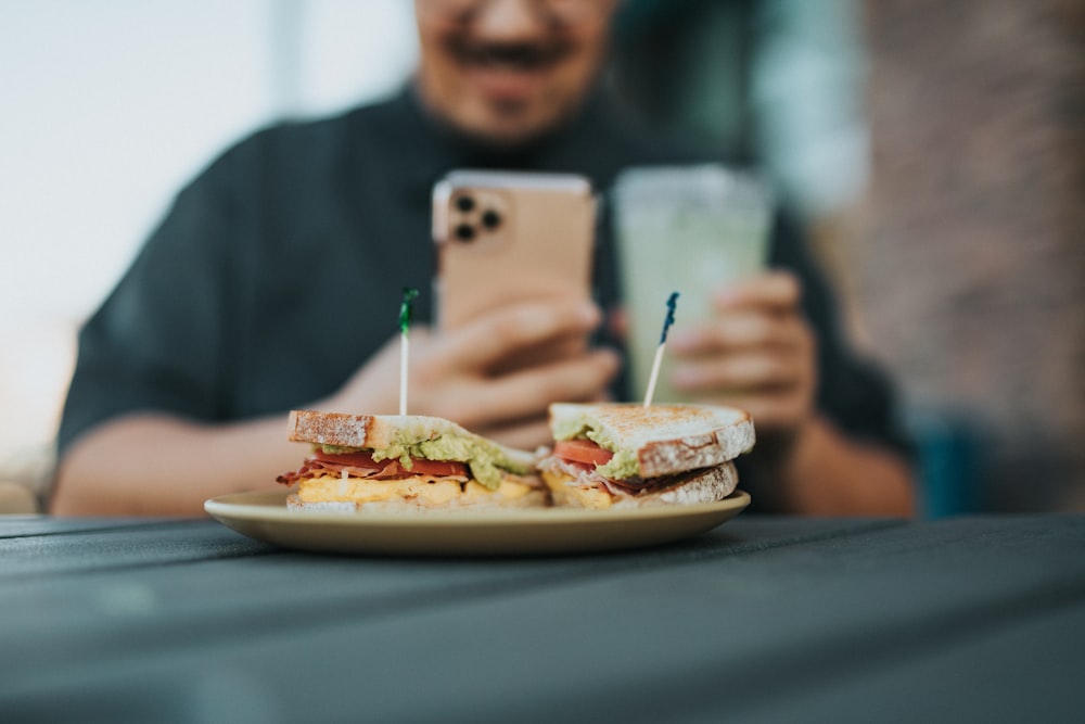 man in gray sweater holding silver iphone 6