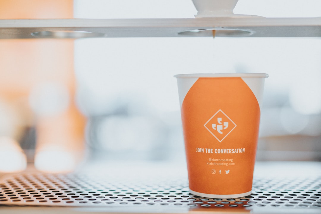 orange and white disposable cup