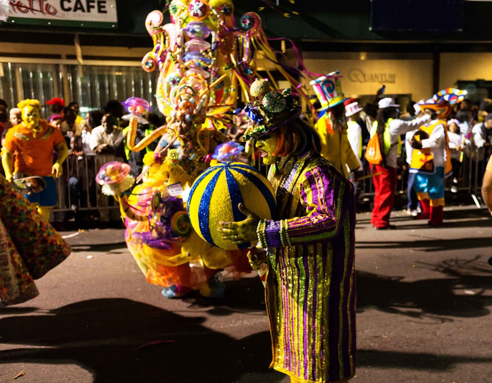 um homem vestido com uma roupa colorida e segurando uma bola