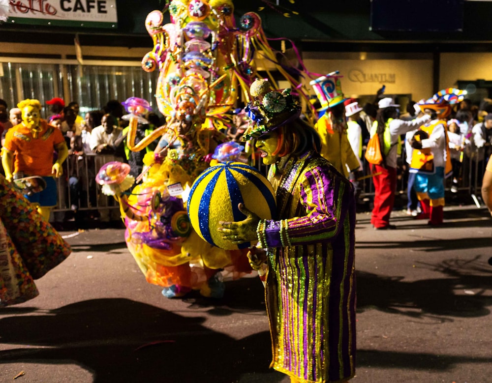 Un hombre vestido con un traje colorido y sosteniendo una pelota