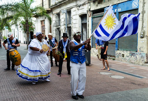 a group of people walking down a street holding flags