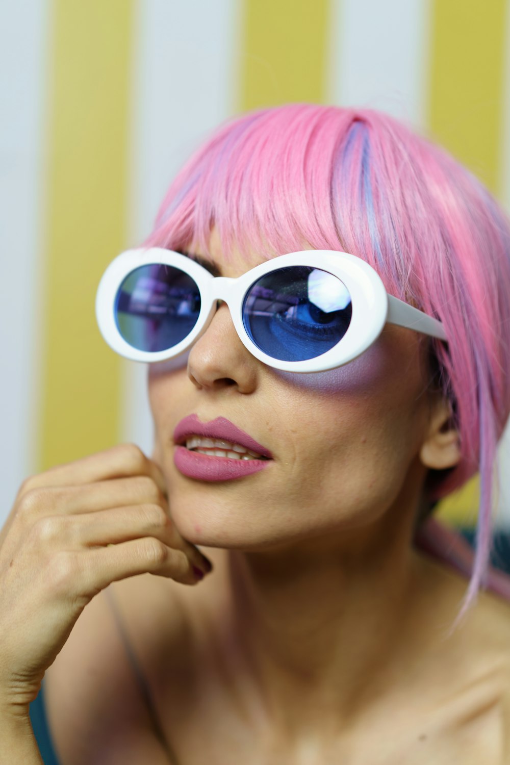 woman in pink hair wearing white framed sunglasses