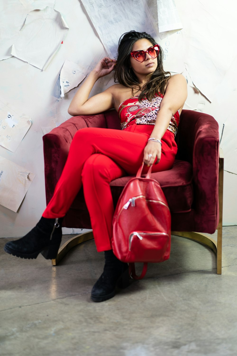 woman in red and white floral dress sitting on red sofa