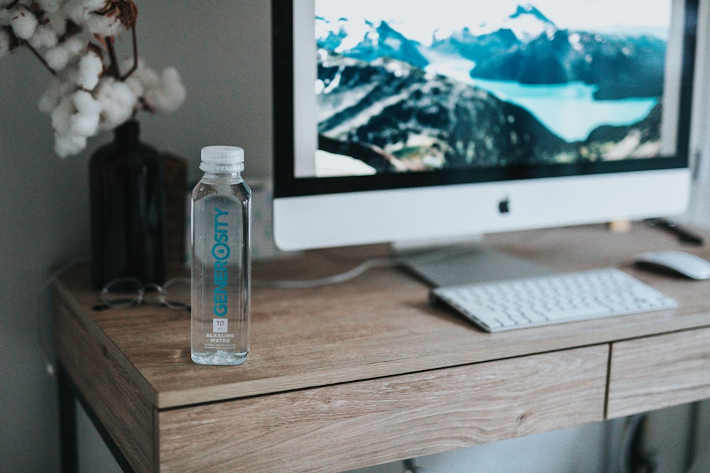 clear plastic bottle beside silver imac