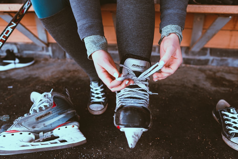 person in black and white adidas sneakers holding white smartphone