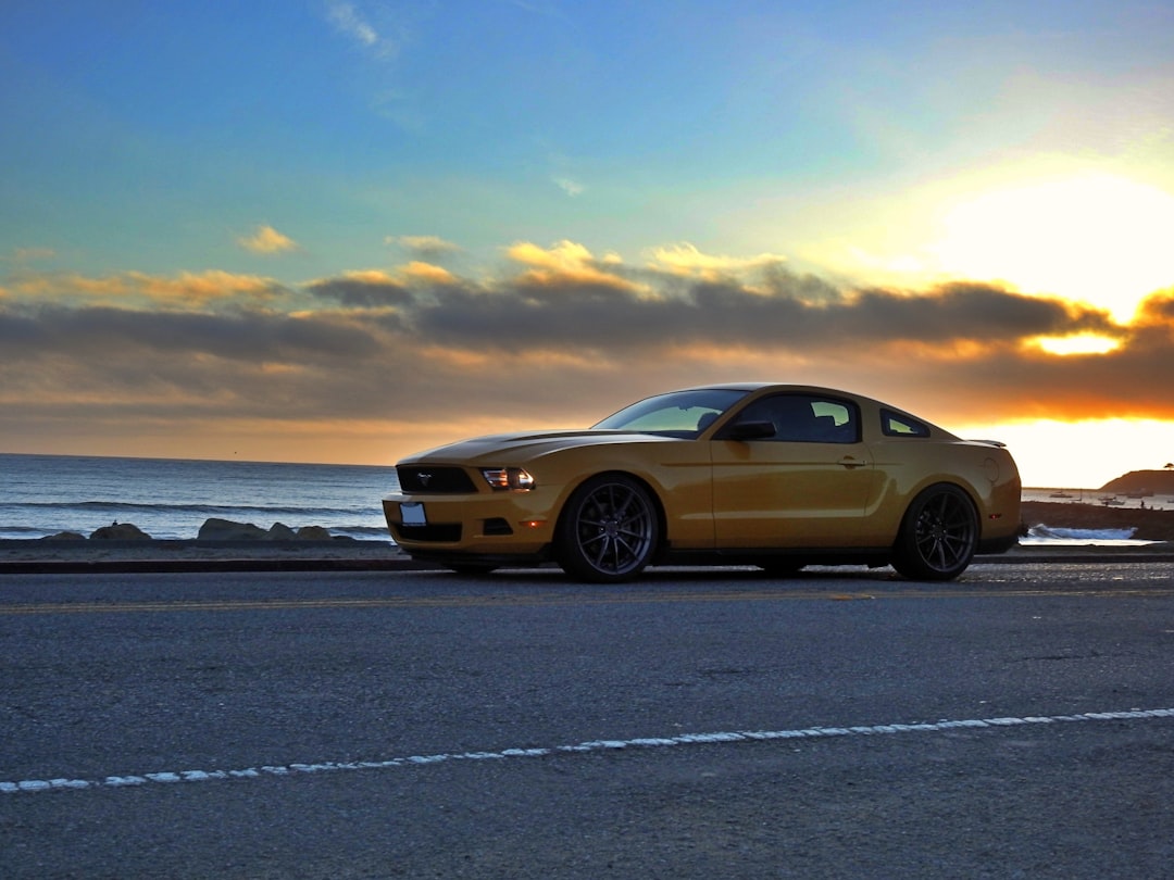 yellow sedan on gray asphalt road during daytime