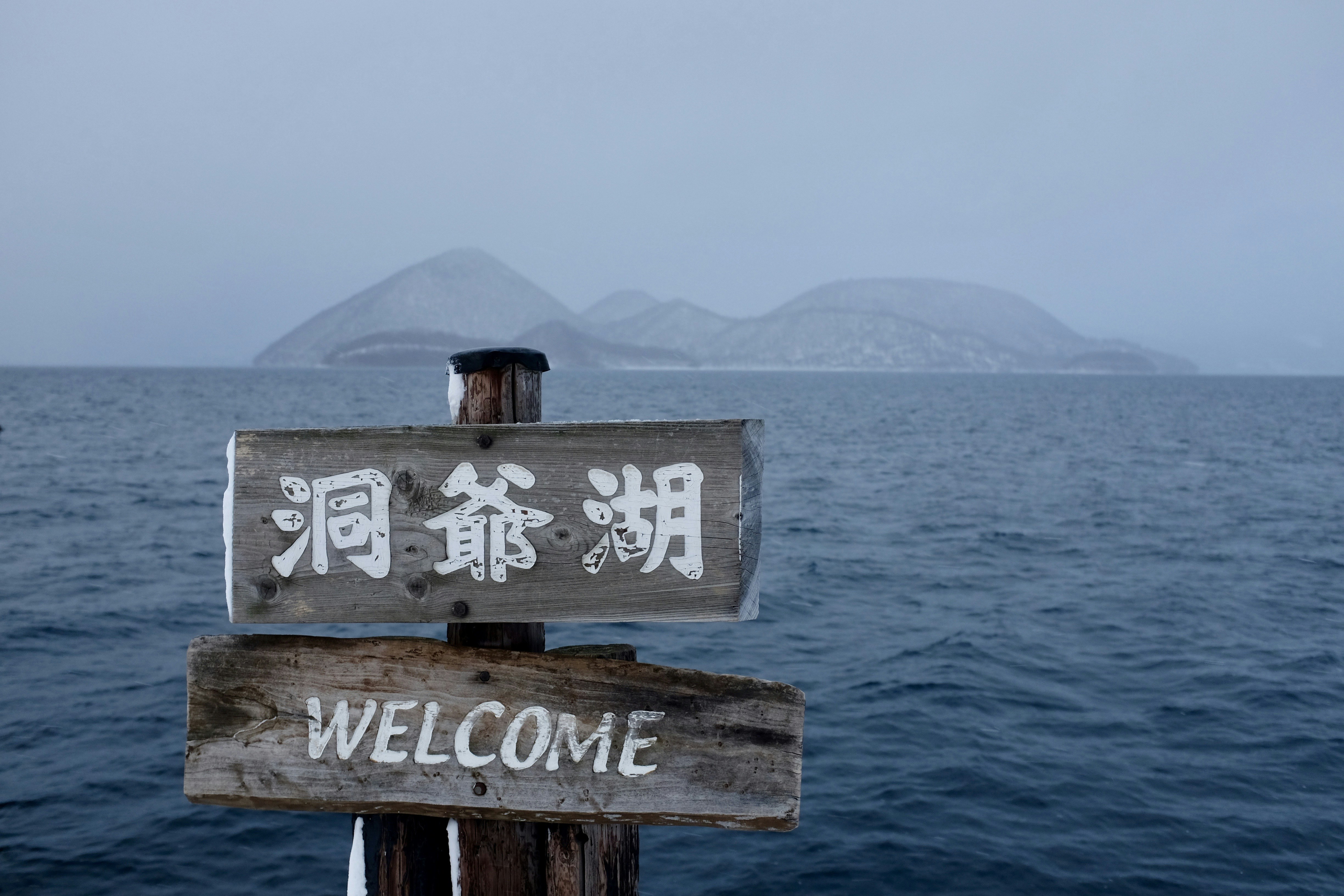 brown wooden signage on sea during daytime