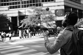 grayscale photo of person in hoodie holding round ball