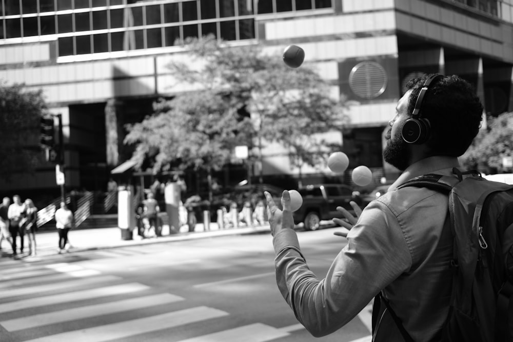 grayscale photo of person in hoodie holding round ball