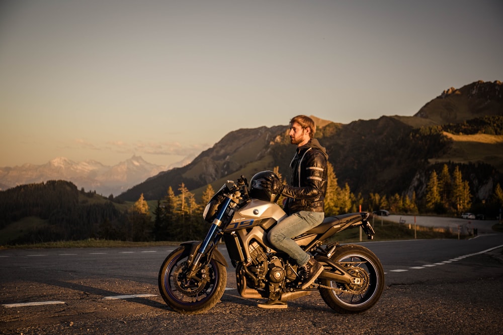 man in brown jacket riding on white and black motorcycle