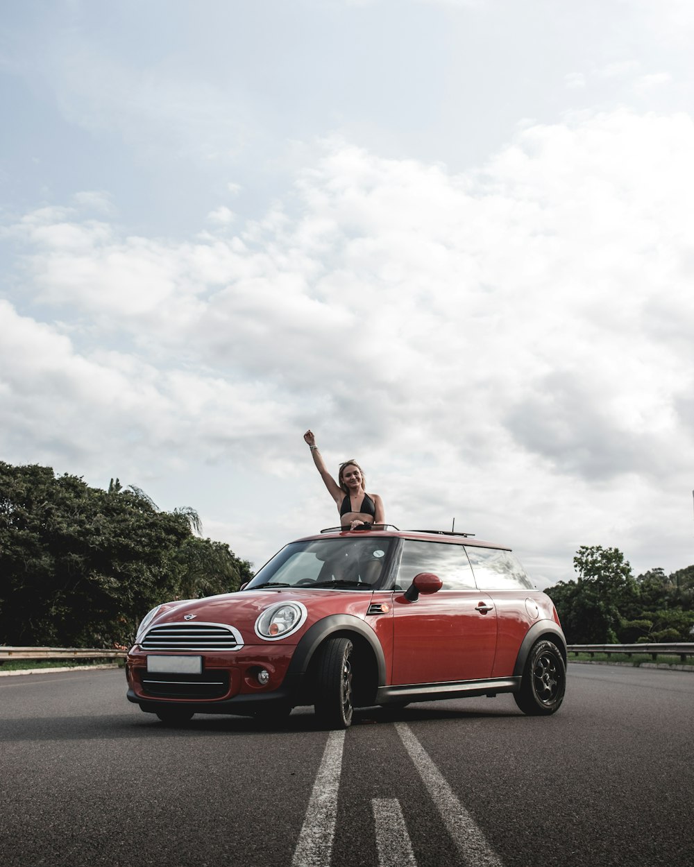 man in red convertible car on road during daytime