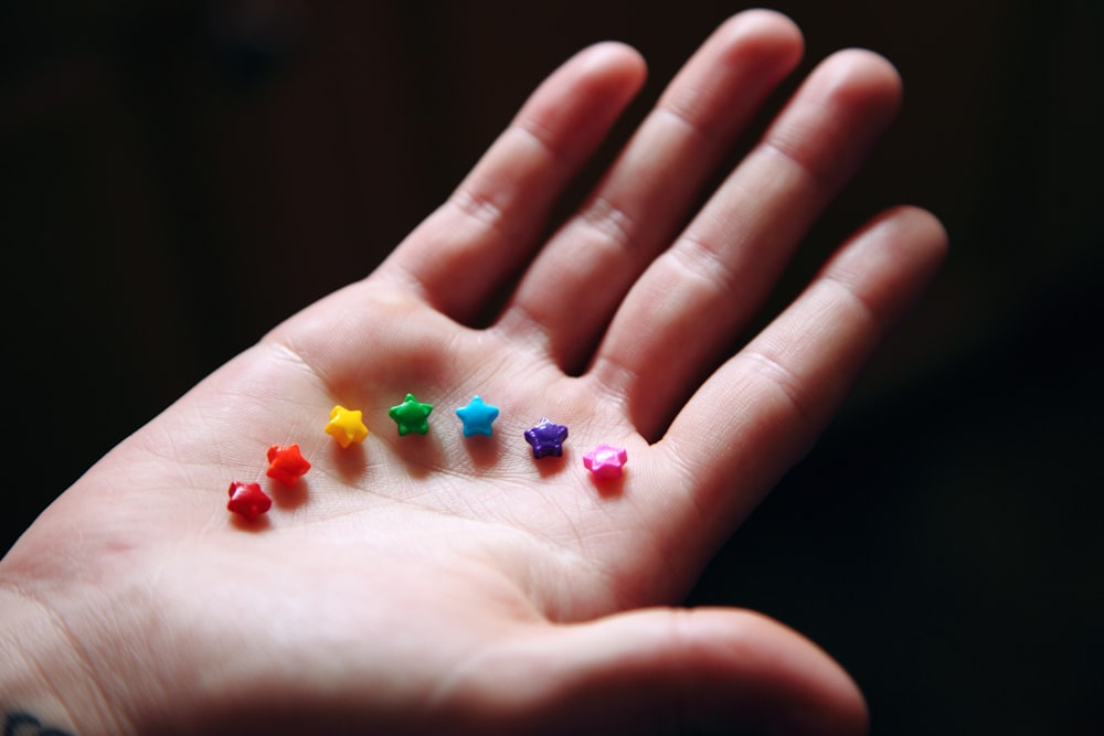 person holding blue green and orange beads