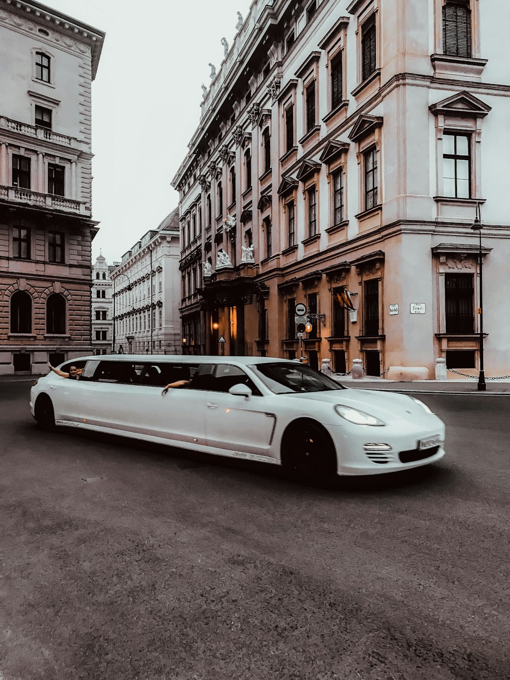 Weiße Limousine tagsüber neben weißem Betongebäude geparkt