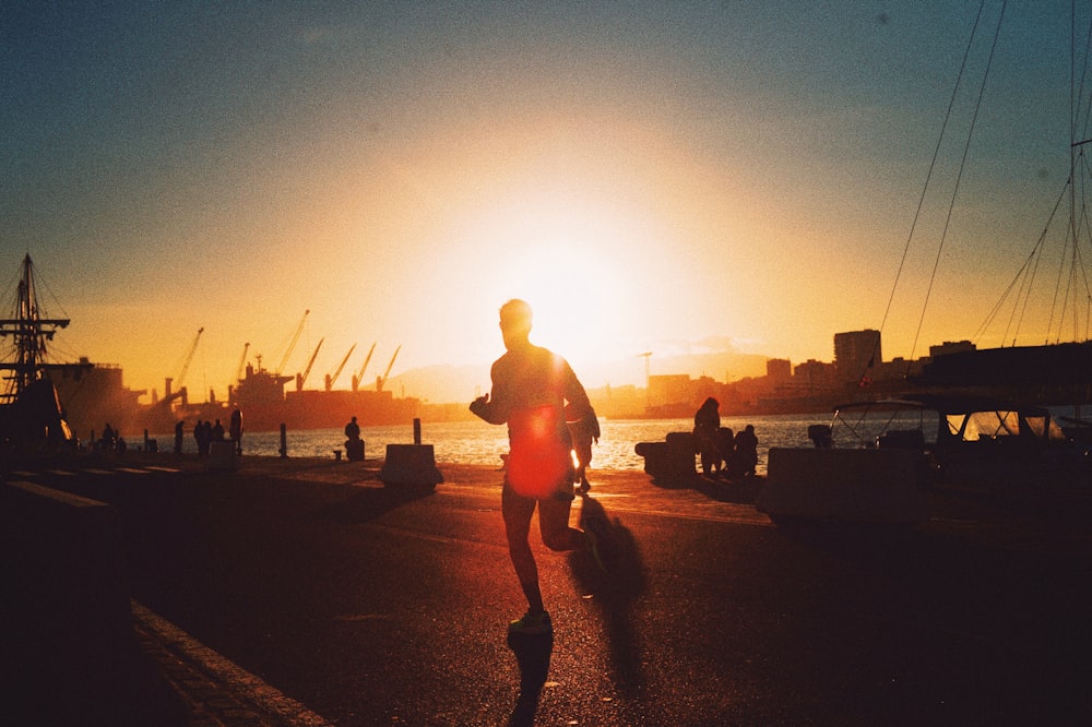 silhouette of man walking on the street during sunset