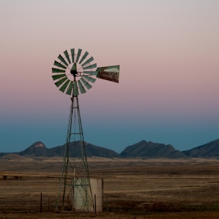 brown windmill on brown field during daytime