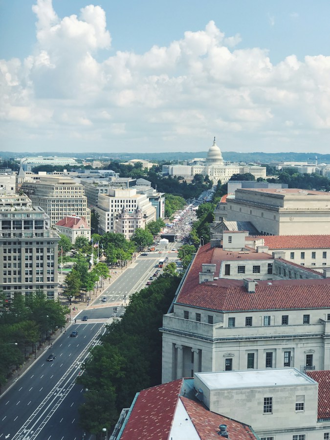Aerial view down a Washington DC avenue with the domed US Capitol building in the distance among federal buildings