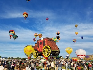 people gathering in a street with hot air balloons