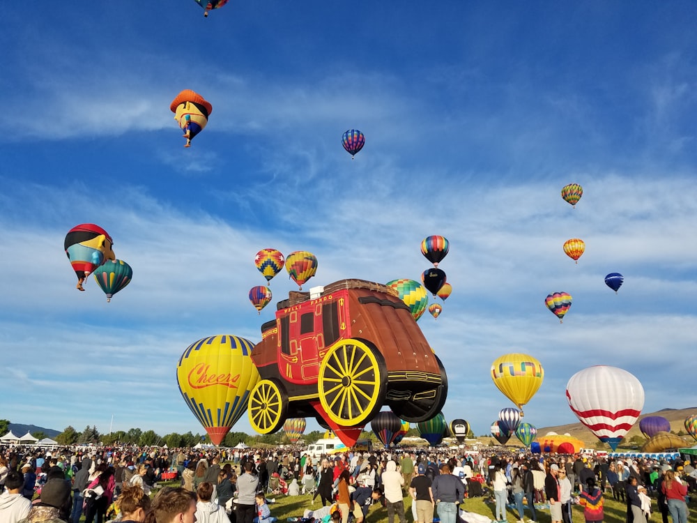 people gathering in a street with hot air balloons