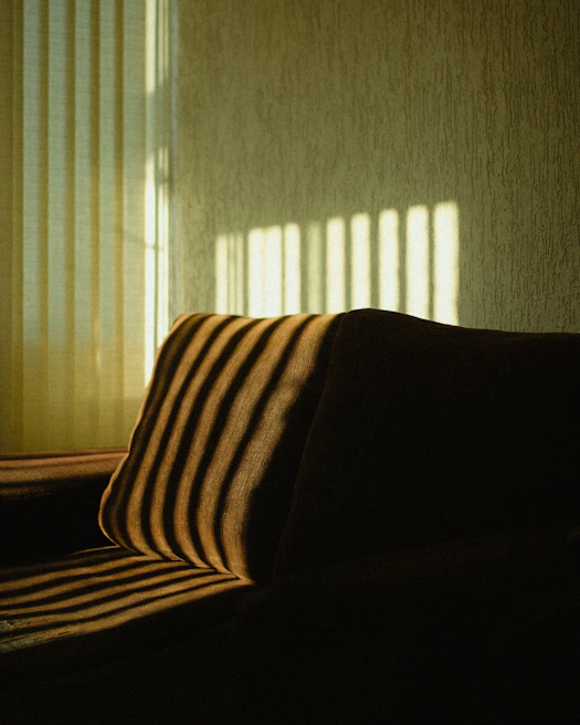 A stylish villa living area bathed in warm light controlled by a custom-fitted roller blind