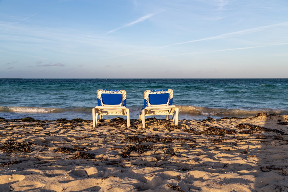 fauteuil en bois blanc sur le rivage de la plage pendant la journée