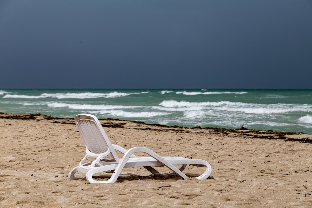 white plastic armchair on beach shore during daytime