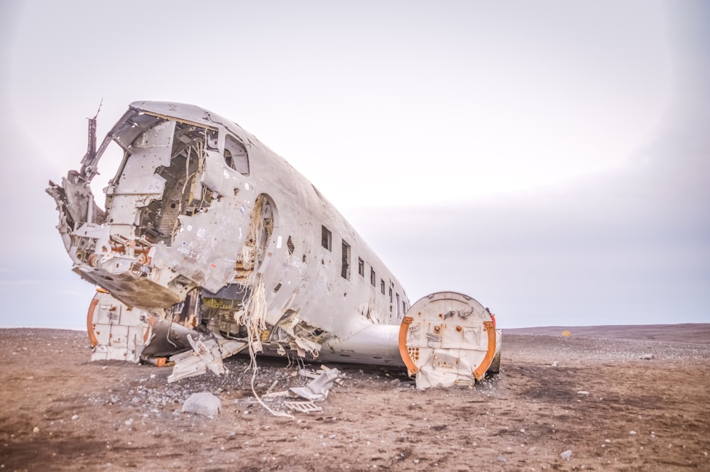 wrecked airplane on brown sand during daytime